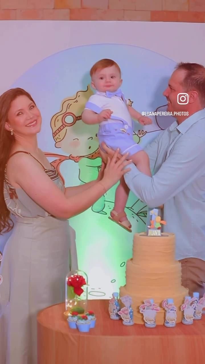 Família celebrando o primeiro ano do bebê diante da mesa do bolo